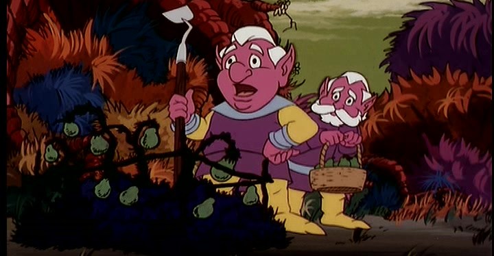 Dois dos trobits, criaturas de fantasia do tipo anão com pele magenta brilhante e cabelos brancos, usando túnicos roxos e meias amarelas, ficam juntas em frente a um maço de bramble em uma cena de Blackstar