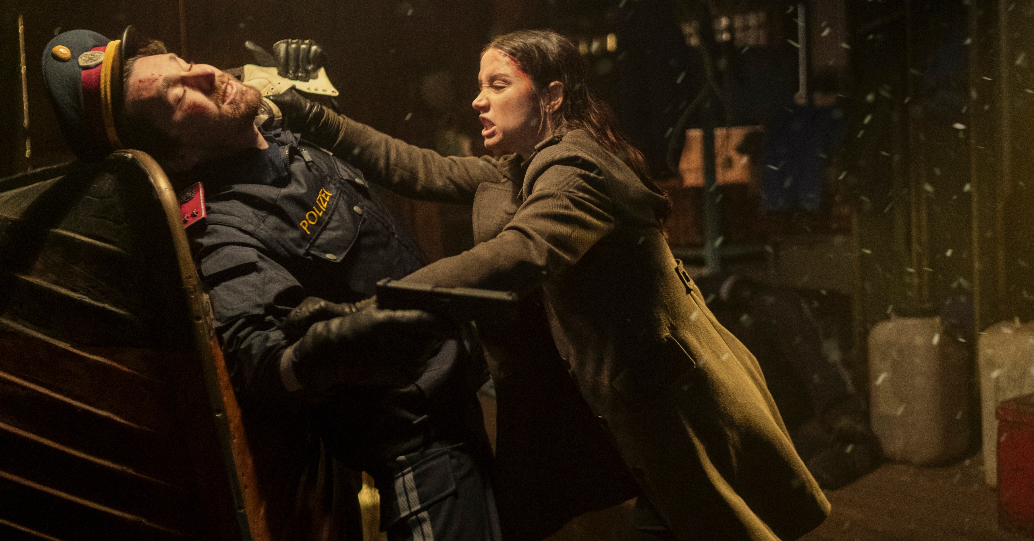 Eve (Ana de Armas) estrangula um homem que empunhava armas em um chapéu militar retro e um coato de trincheira no spin-off de John Wick-off