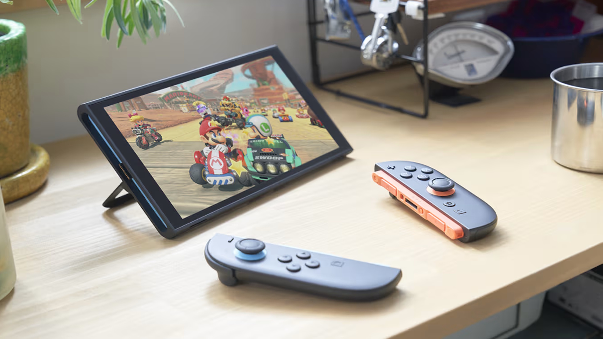 Dois Switch 2 Joy-Con destacados em uma mesa na frente de um interruptor 2 no modo de mesa, executando o Mario Kart World