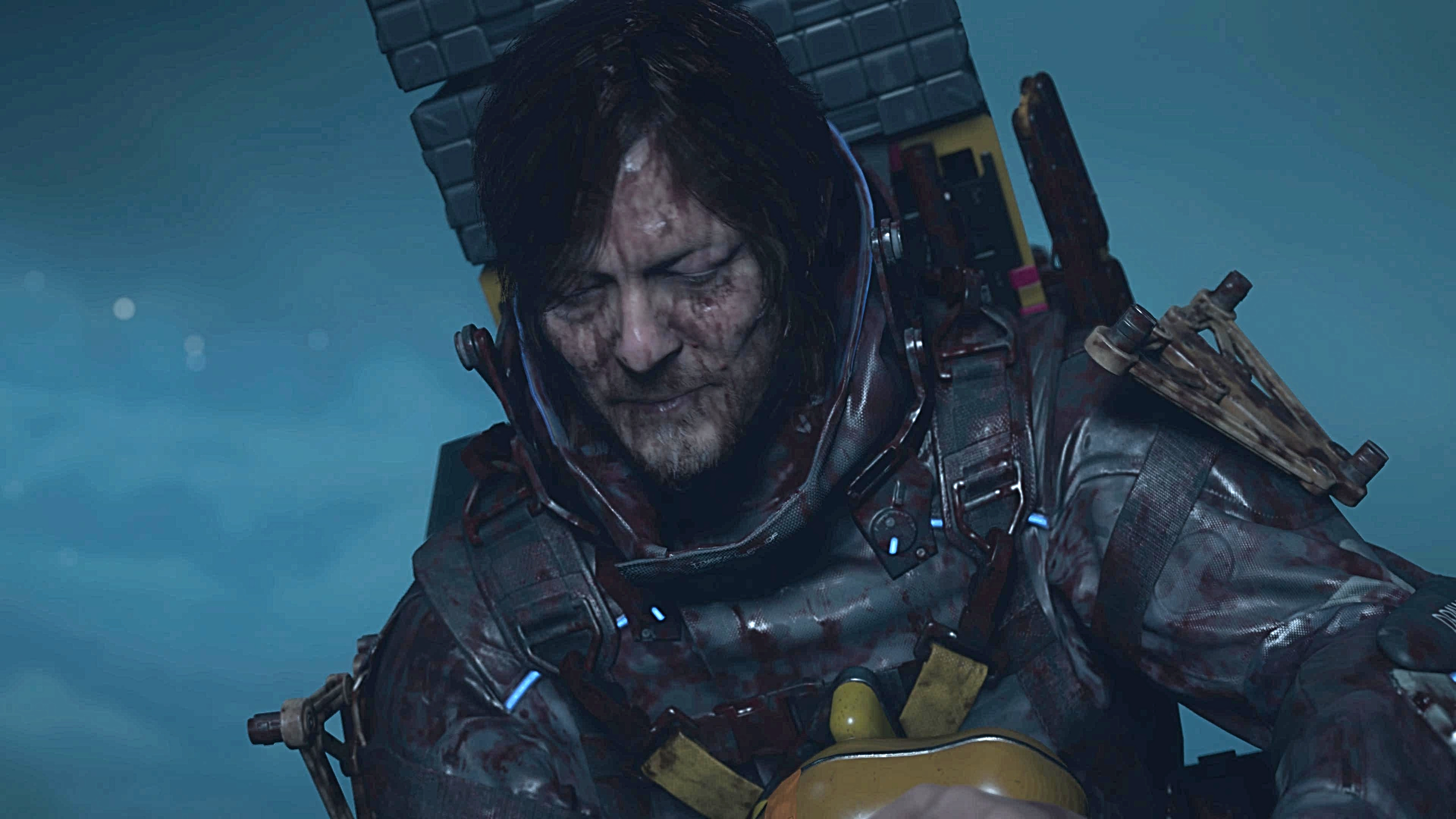 Sam de Death Stranding 2, parecendo cansado e usado com o alcatrão de seus olhos