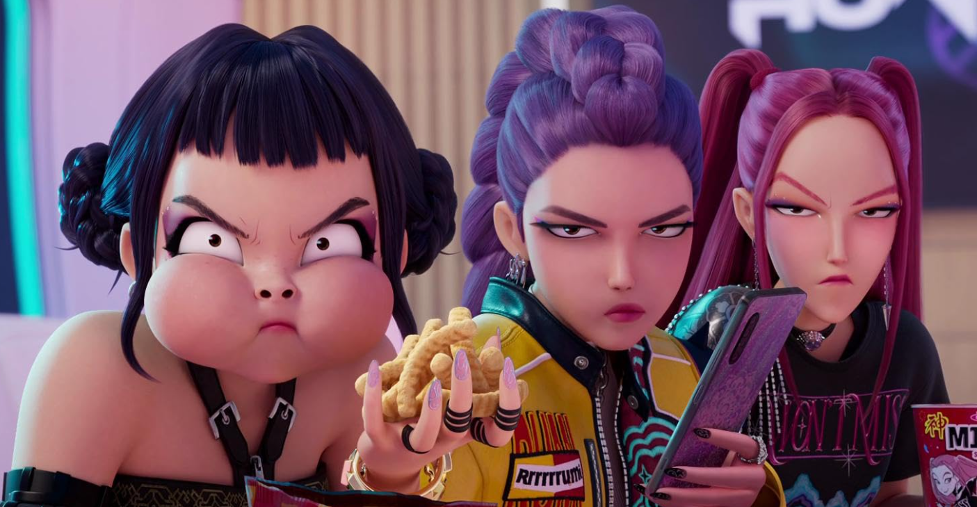 Três jovens brilham. A primeira tem comida na boca, a segunda segura um telefone e a terceira xícara de Ramyeon. Eles parecem distintamente impressionados. Dos caçadores de demônios do K-pop da Netflix.