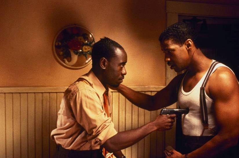 Don Cheadle, tocando o mouse do gatilho de cabelo, segura uma arma para o detetive Easy Rawlins, interpretado por Denzel Washington, em uma cena de Devil In A Blue Dress