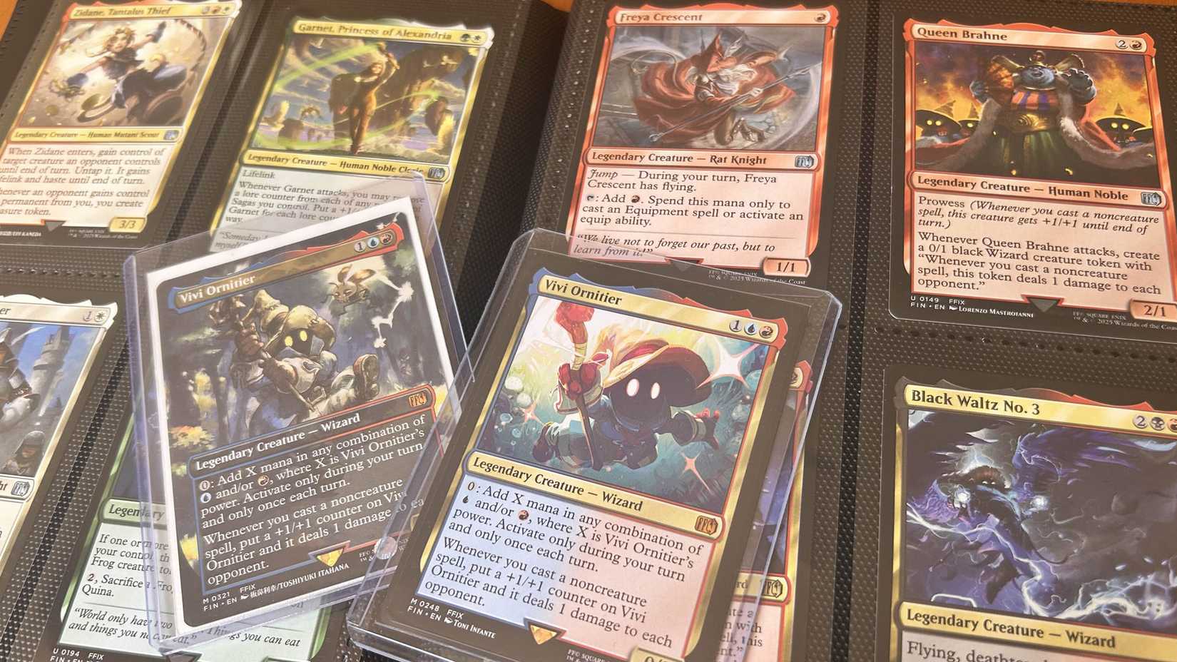 Uma foto mostrando um pouco de mágica de Final Fantasy: The Gathering Cards, concentrando -se em duas cópias de Vivi Ornitier
