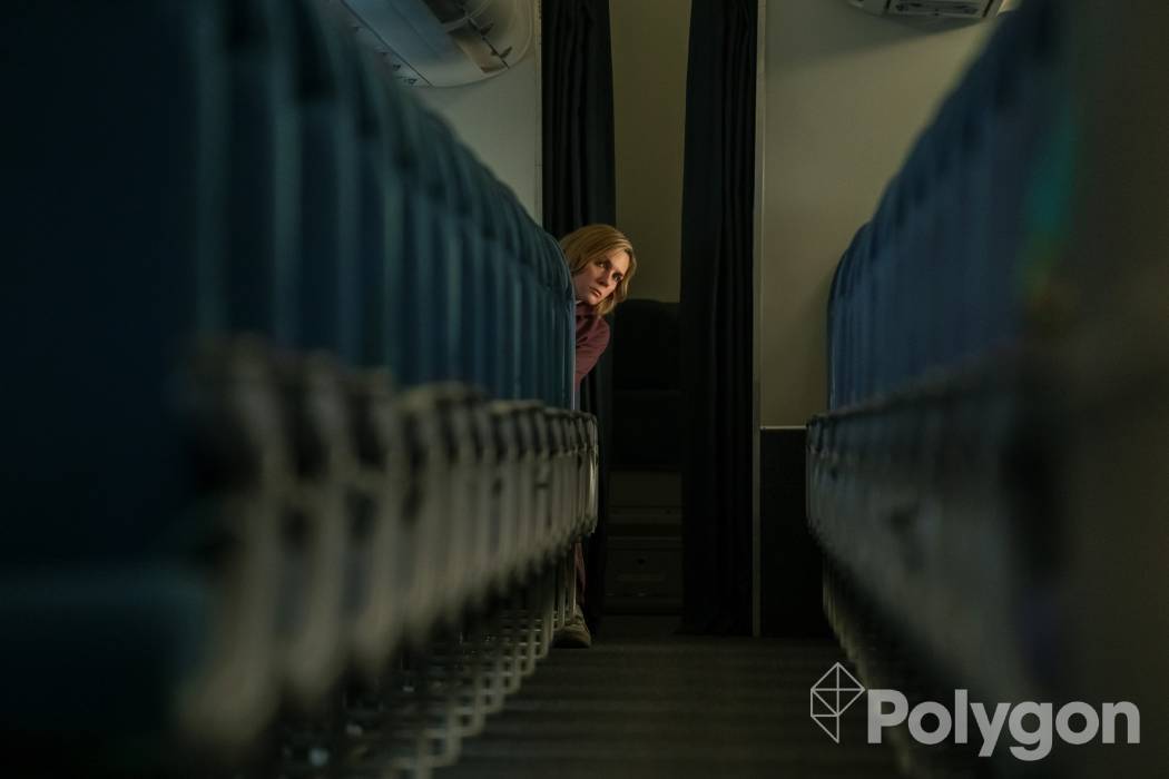 Rhea Seehorn sentado na parte de trás de um avião vazio em pluribus