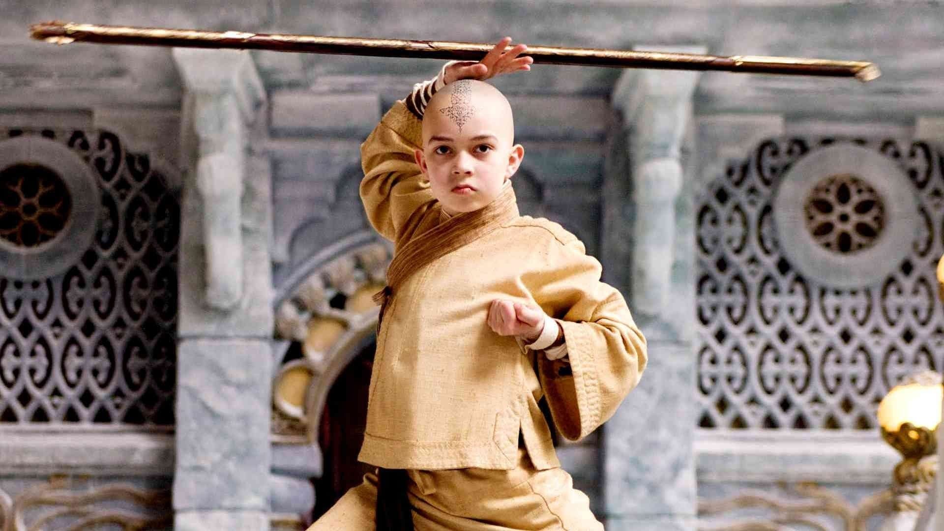 Aang (Noah Ringer) segurando sua equipe acima de sua cabeça no filme de 2009 The Last Airbender