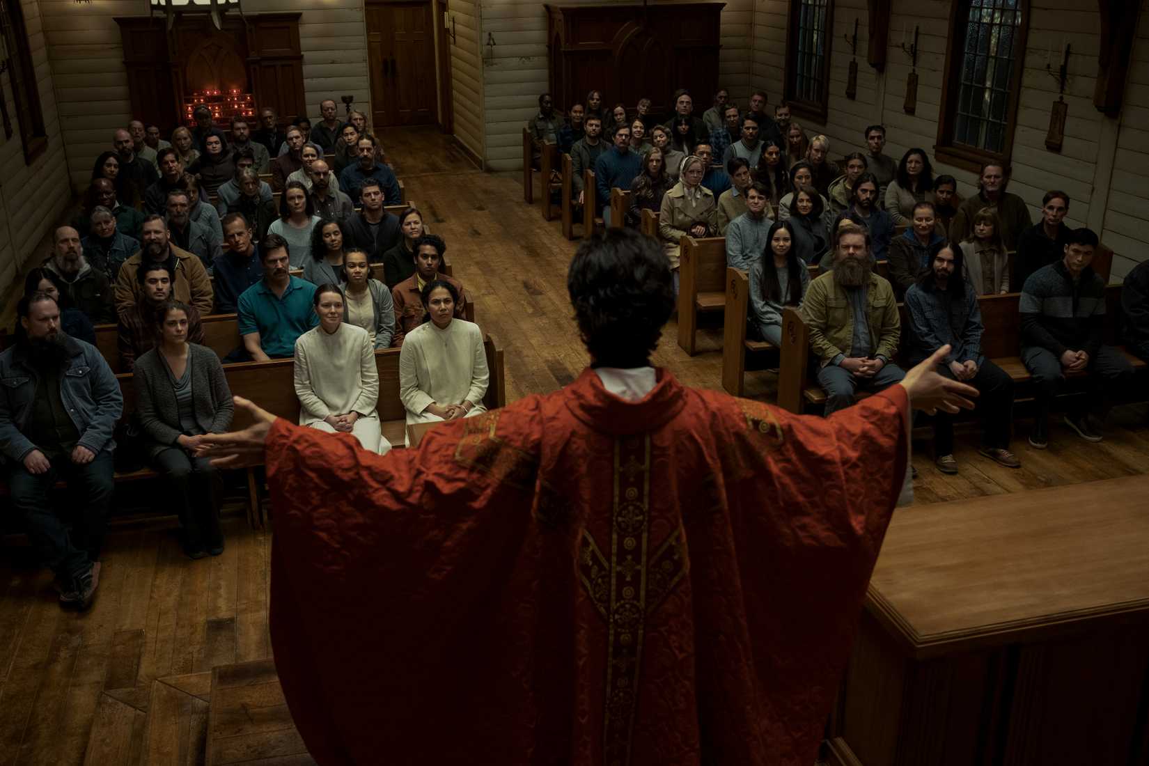 Um padre misterioso lidera uma missa em uma igreja de madeira antiga na missa da meia -noite