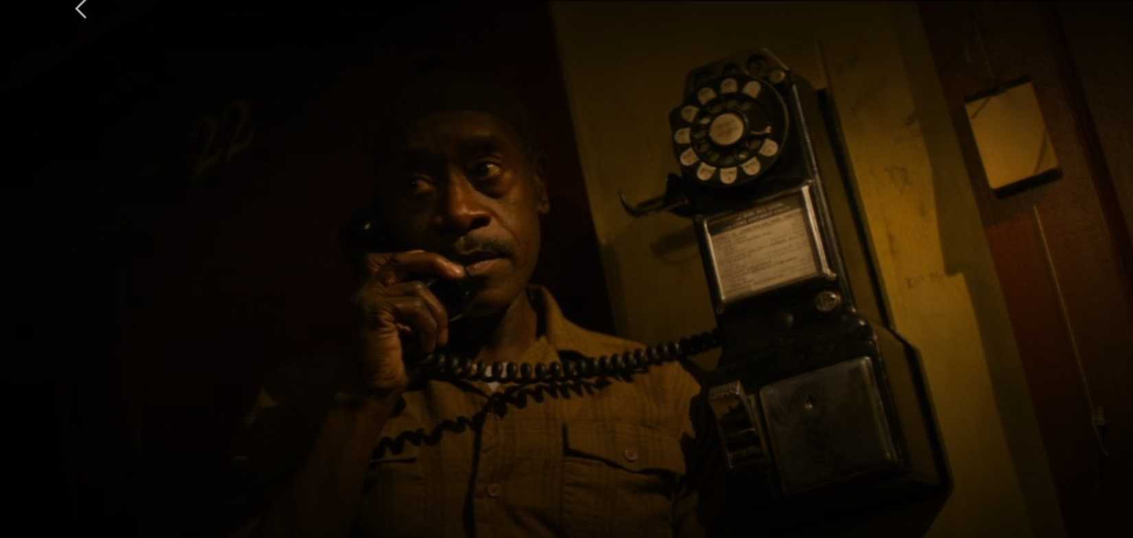 Don Cheadle atende um telefonema sombrio em uma cena de sem movimento repentino