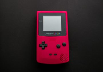Close-up of a red Nintendo Game Boy Color on a dark backdrop, showcasing retro gaming nostalgia.