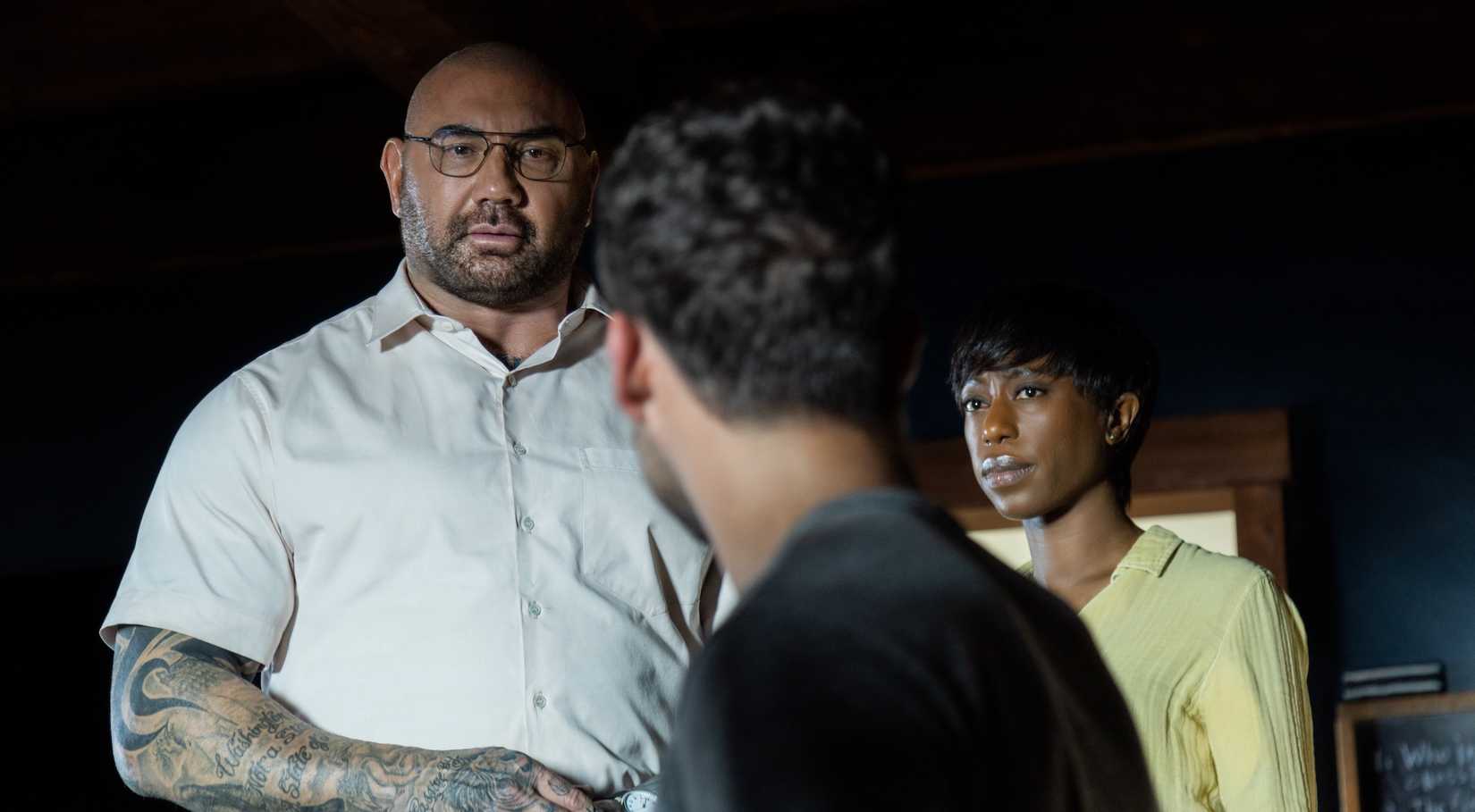 Invasor de casa Leonard (Dave Bautista) paira sobre seu cativo Eric (Jonathan Groff) como companheiro de Leonard Sabrina (Nikki Amuka-bird)