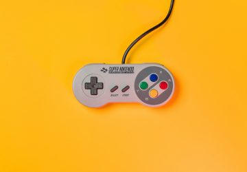 white nintendo game controller on yellow surface