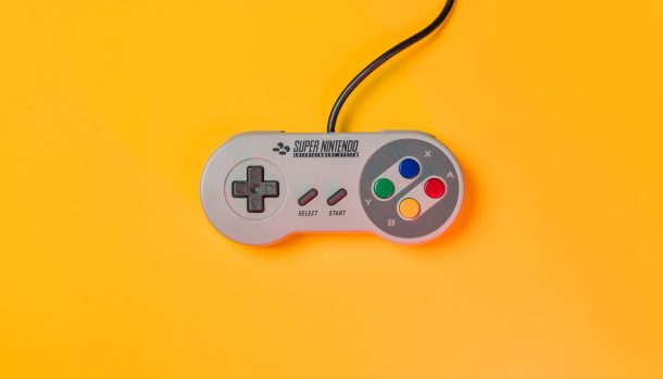 white nintendo game controller on yellow surface