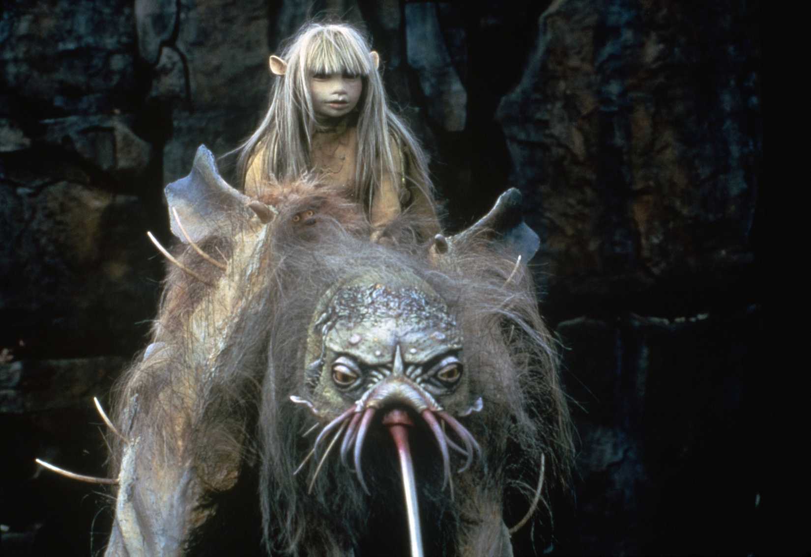 Um personagem humanóide com cabelos compridos anda de uma criatura com características de tândega no cristal escuro