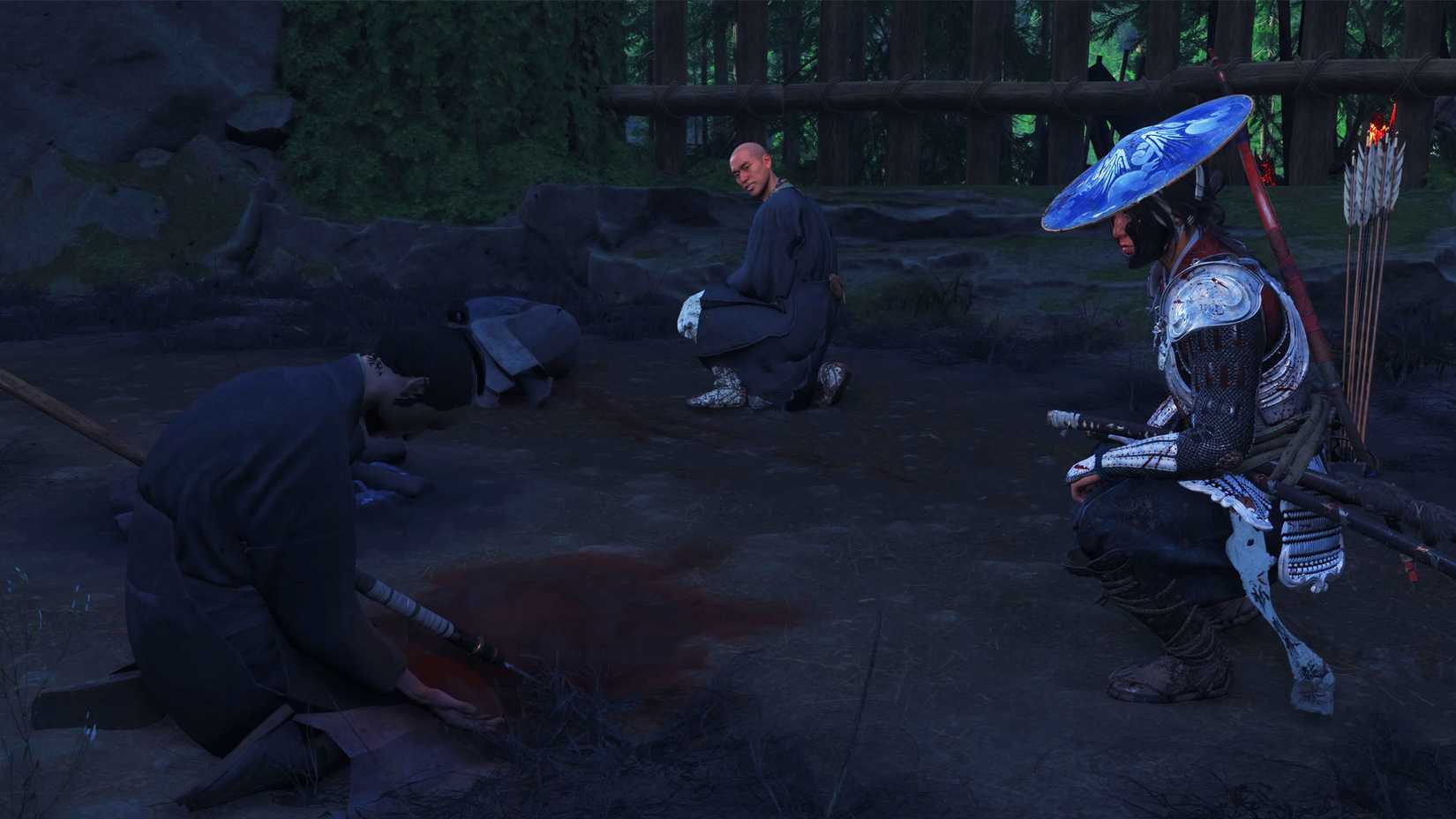 Uma captura de tela de Ghost of Yotei mostrando Atsu e um curandeiro perto do corpo de um homem morto por uma lança deixada em seu corpo