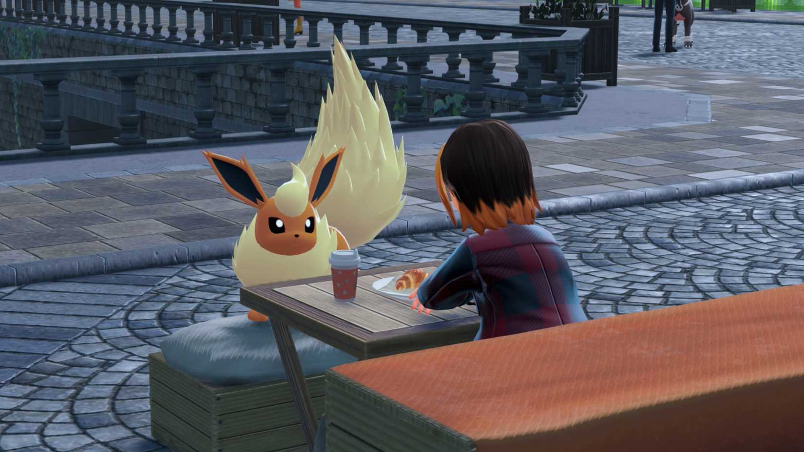 Um Flareon encara seu treinador sentado com café e um doce em Pokémon Legends: Arceus.