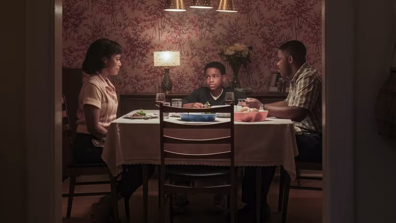 Charlotte, Leroy e Will Hanlon (Taylour Paige, Blake Cameron James, Jovan Adepo) sentados à mesa de jantar de TI: Bem-vindo a Derry