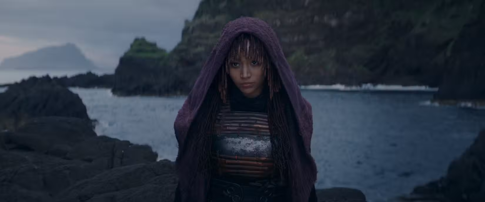 Amandla Stenberg parecendo vagamente malvada sobre a face de um penhasco em frente à água em The Acolyte