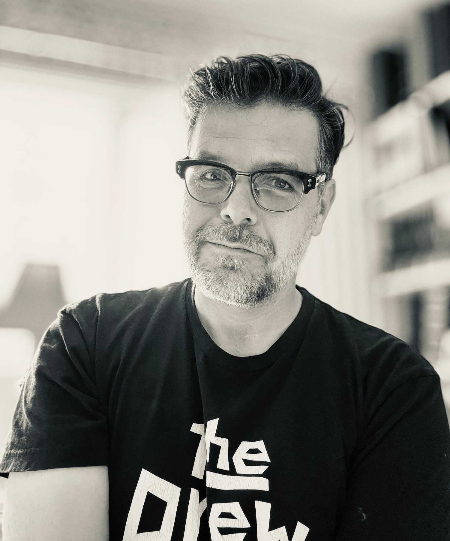 Phil Johnston, um homem com barba aparada e óculos