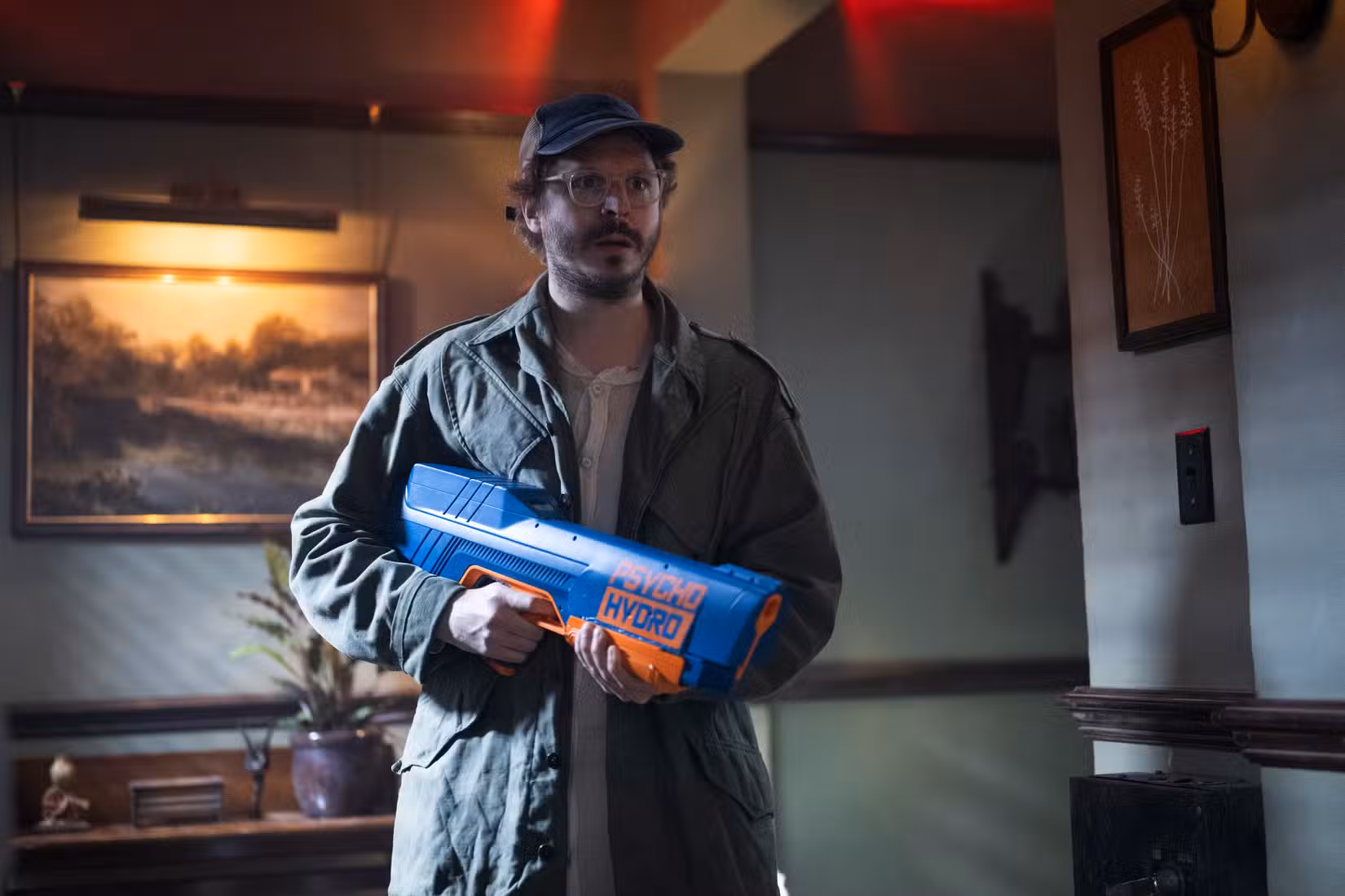 Michael Cera segura um super absorvente de plástico gigante em uma cena de The Running Man, de 2025