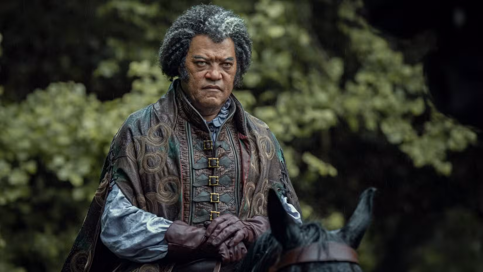 Regis (Laurence Fishburne) monta um cavalo preto em The Witcher