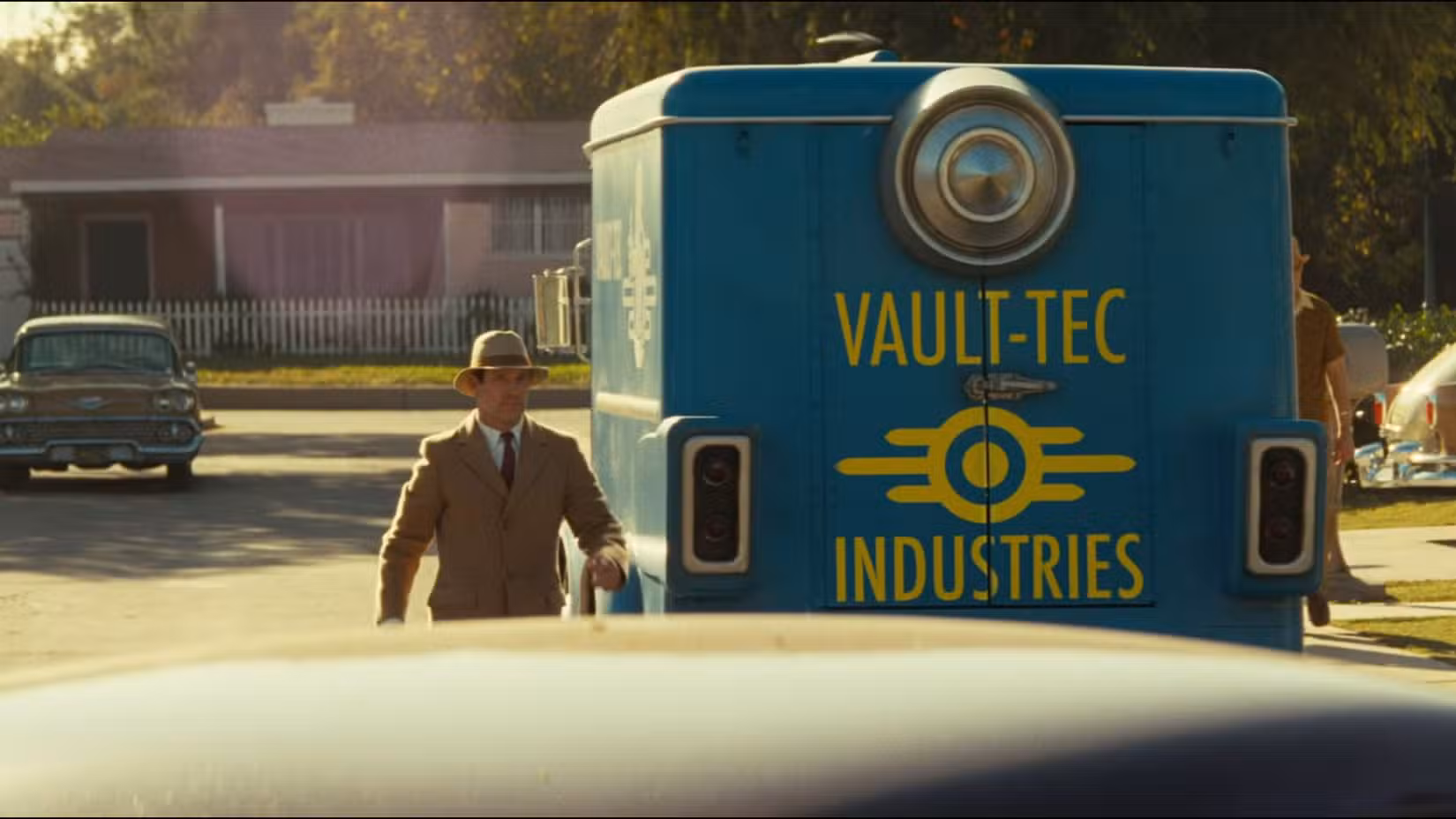 Um representante da Vault Tec andando em volta de seu carro no episódio 1 da 2ª temporada de Fallout.