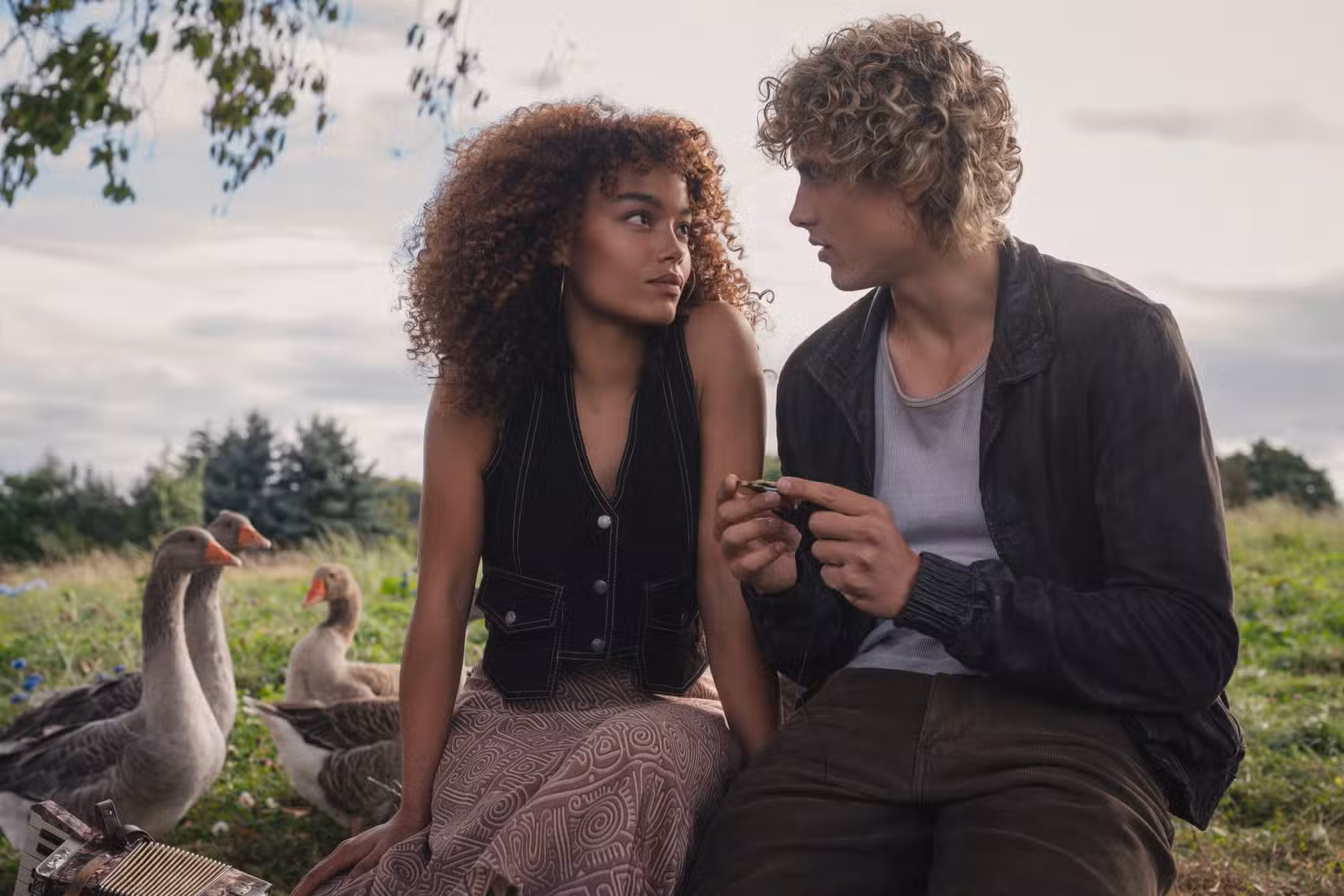 Uma foto do trailer de Jogos Vorazes: Sunrise on the Reaping mostrando Haymitch sentado em um campo com uma garota