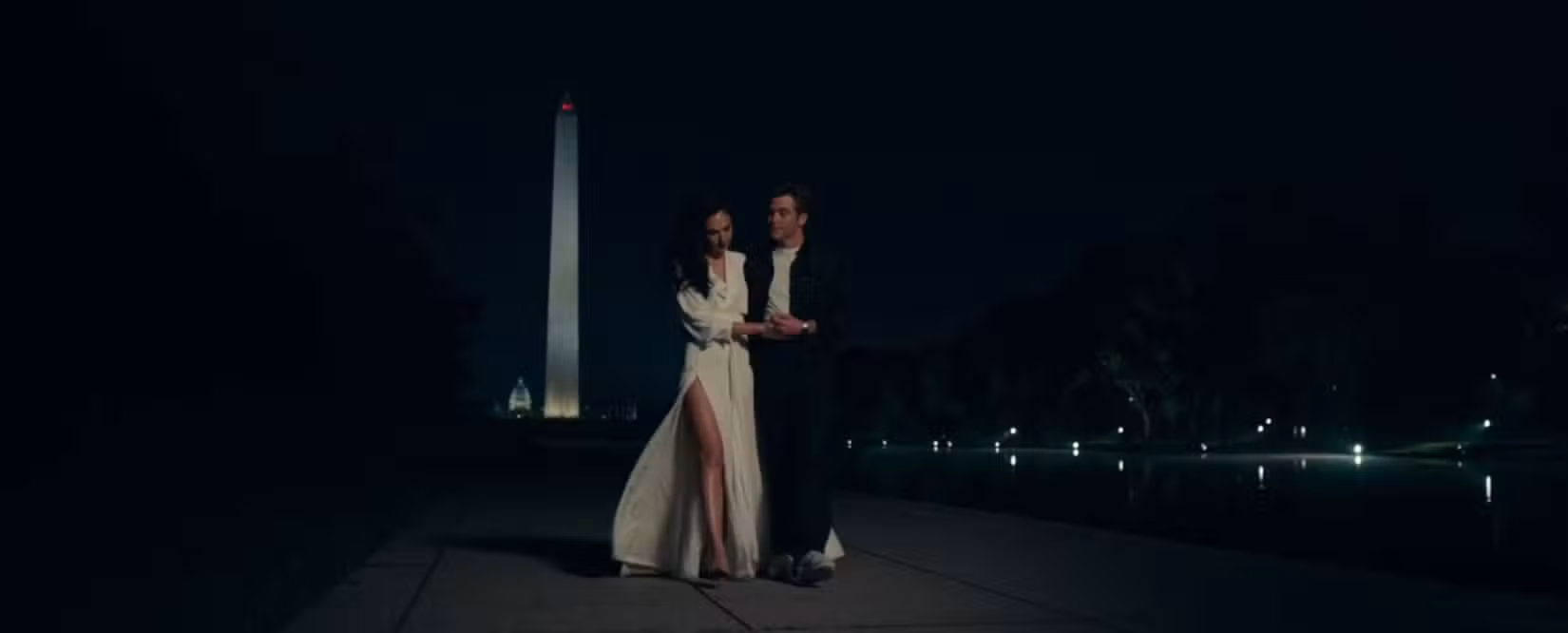 Em uma cena de Mulher Maravilha 1984, Diana (Gal Gadot) e Steve Trevor (Chris Pine) caminham juntos no shopping de Washington, DC à noite, com o Monumento a Washington ao longe