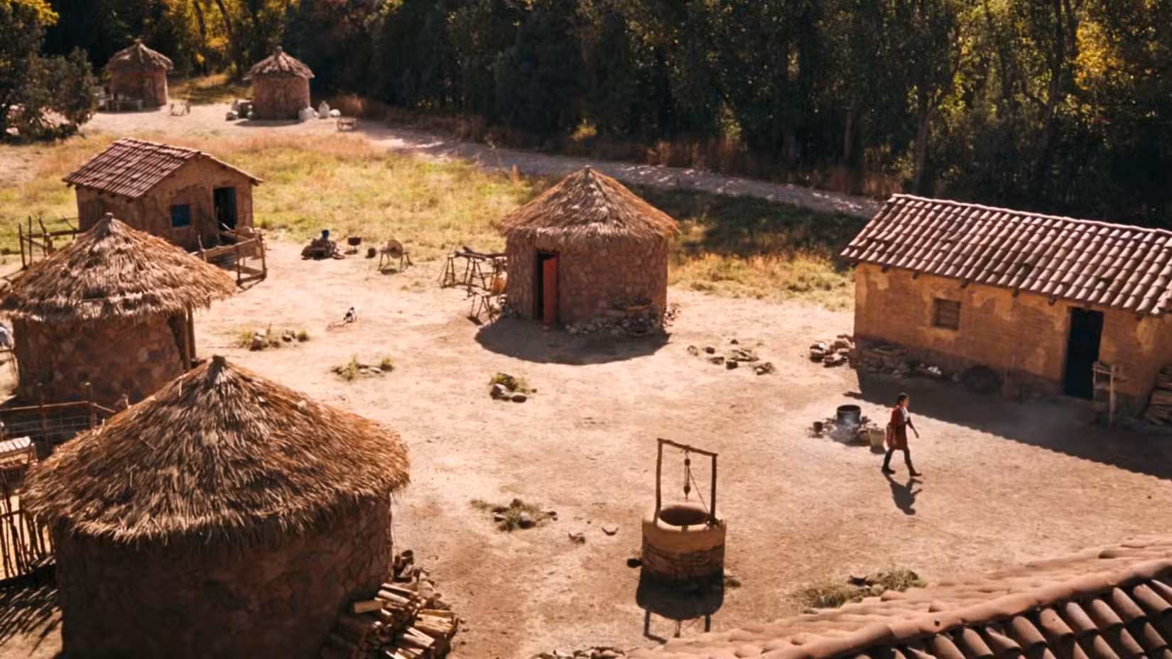Uma imagem do final do Pluribus. Mostra uma aldeia abandonada com uma jovem indo embora, com uma pequena cabra atrás dela.