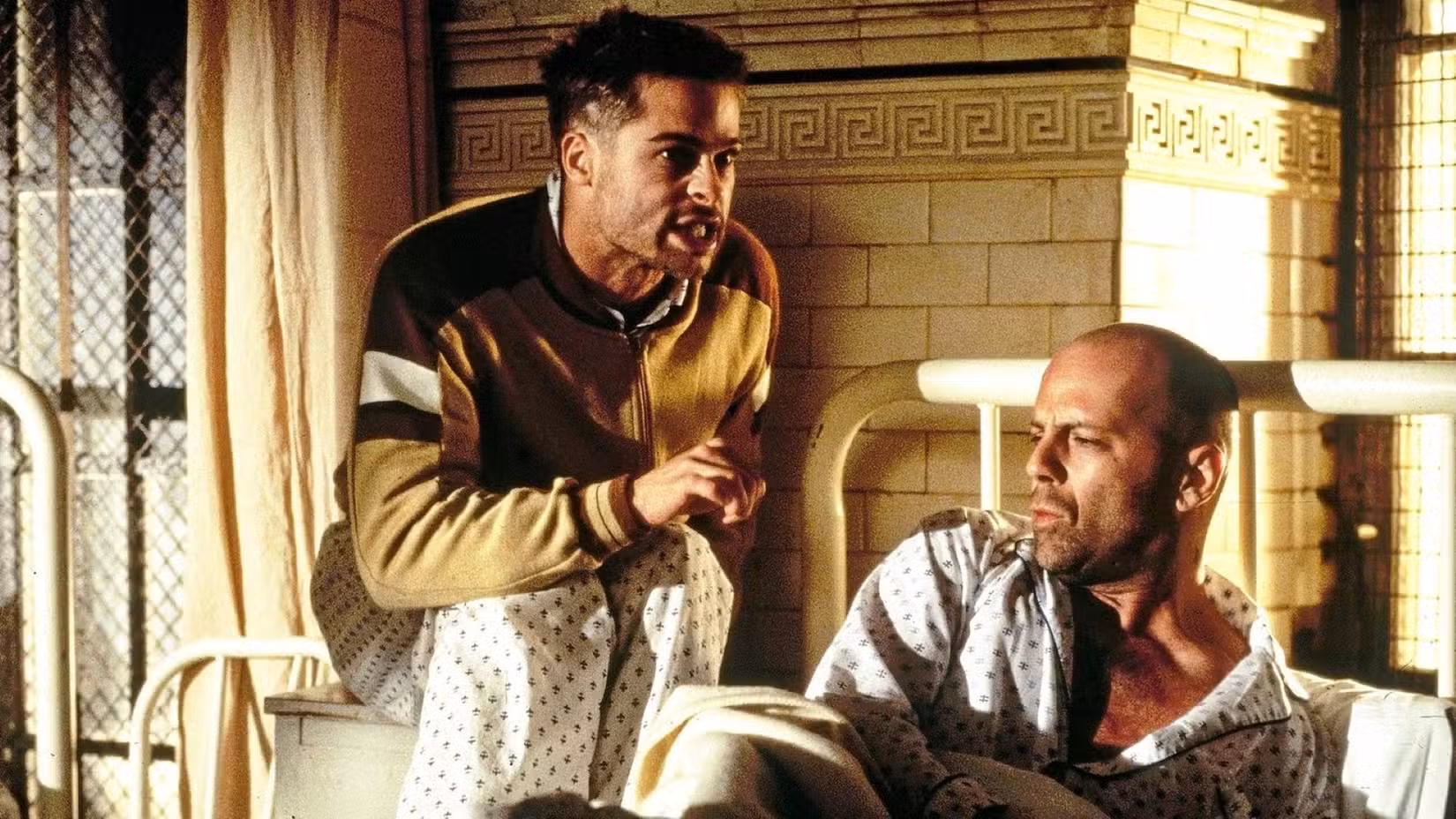 Dois habitantes de uma instituição mental - um revolucionário enérgico e de olhos arregalados, interpretado por Brad Pitt, e um viajante do tempo, interpretado por Bruce Willis - conversam em uma cena do filme 12 Macacos, de Terry Gilliam.