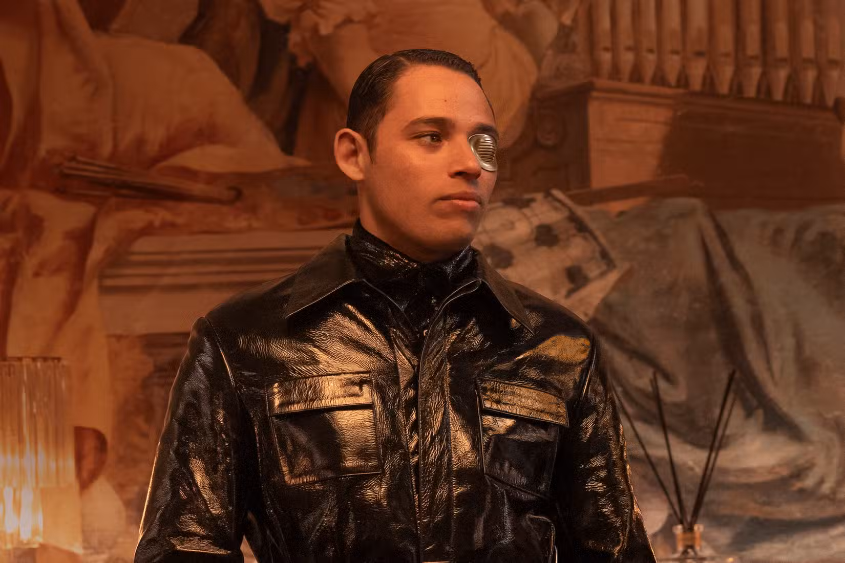 Anthony Ramos como The Assassin, um homem com uma jaqueta de couro brilhante e tapa-olho prateado, em The Beauty
