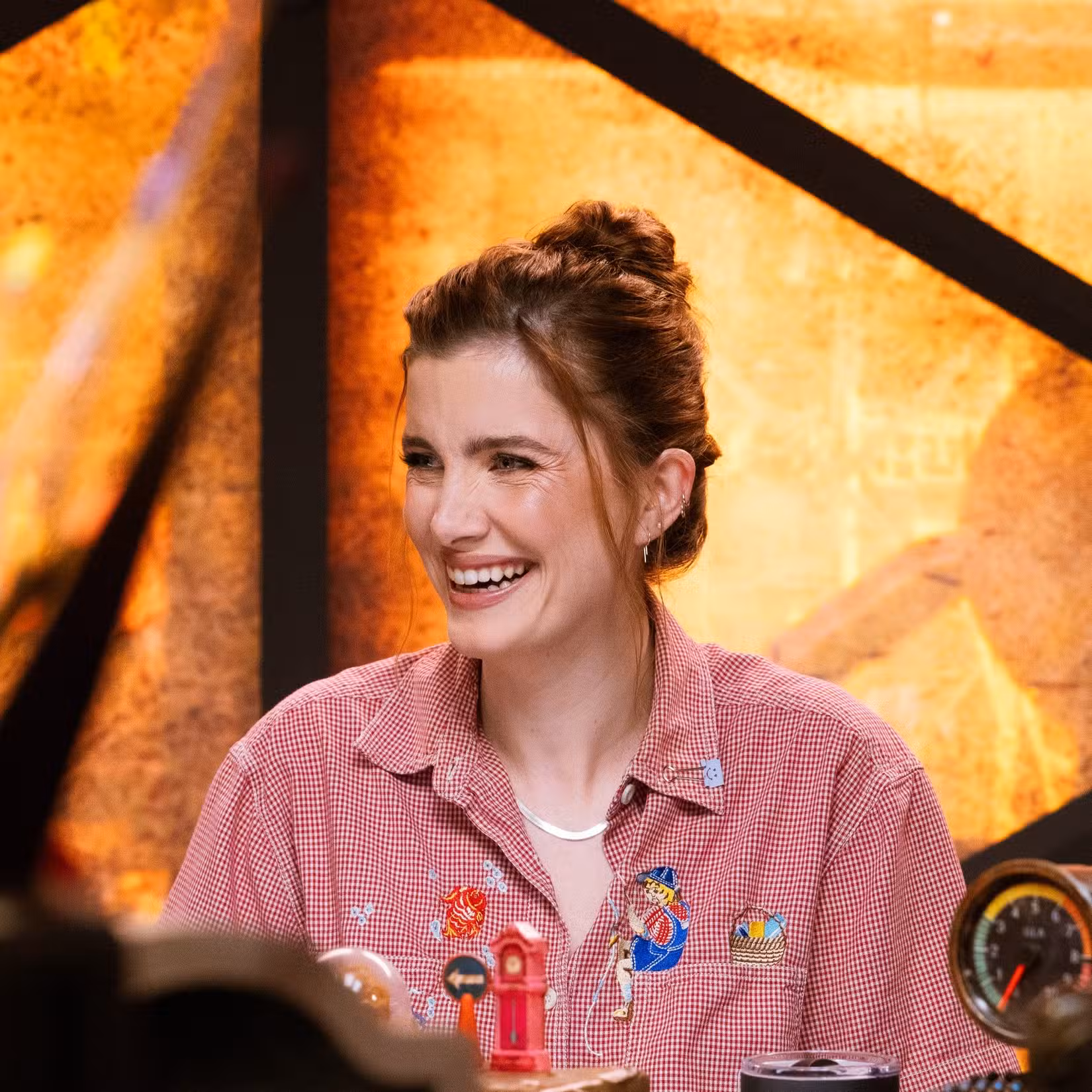 Vic Michaelis sorrindo na mesa para a série de jogos reais da Dimension 20, Gladlands