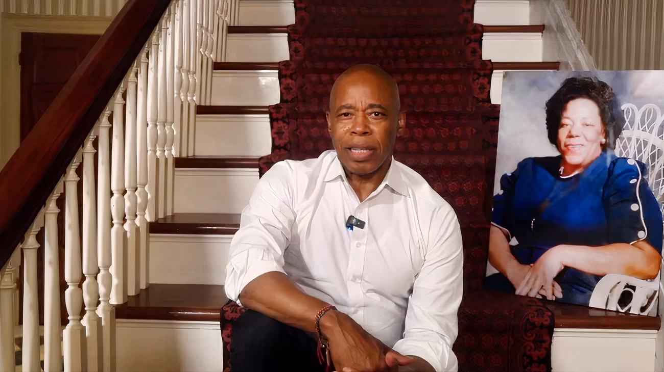 Eric Adams está sentado em uma escada.