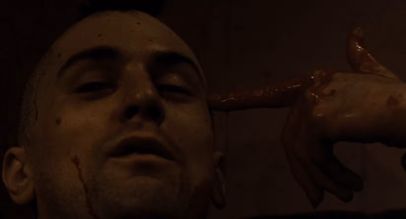 Em uma cena perturbadora de Taxi Driver, Travis Bickle (Robert De Niro), ensanguentado, mas sorridente, com o rosto visto em close, leva a mão encharcada de sangue à cabeça em um gesto de atirar em si mesmo.