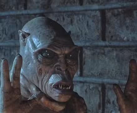 O pequeno diabinho malvado do Portão segurando suas garras de três dedos