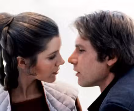 Princesa Leia (Carrie Fisher) e Han Solo (Harrison Ford), em close-up extremo, parecem prestes a se beijar em O Império Contra-Ataca