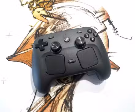 Um controlador Steam fica sobre um mousepad branco.