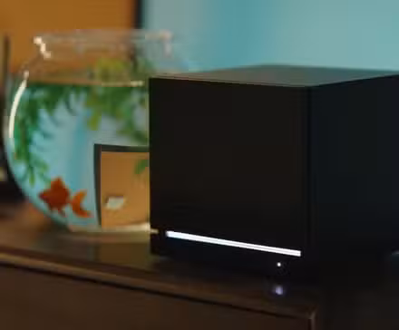 Máquina a vapor da Valve, colocada ao lado de um aquário com peixinhos dourados. 