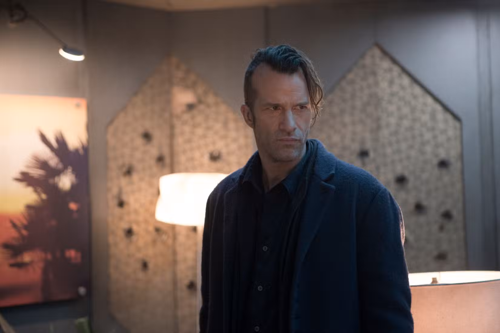 Joe Miller (Thomas Jane), um homem estreito e carrancudo, todo vestido de preto e com um lado da cabeça raspado, em The Expanse