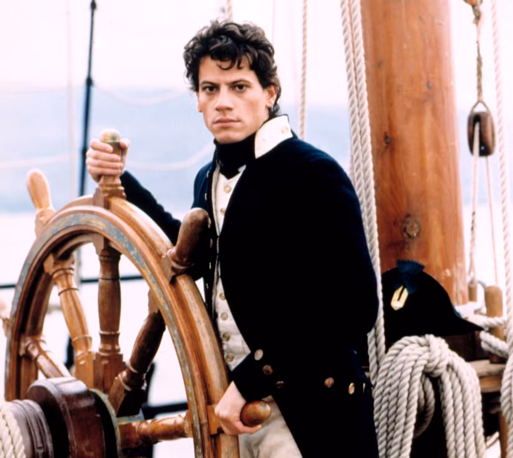 Ioan Gruffudd como o tenente Horatio Hornblower, um homem jovem e pálido com uniforme da Marinha britânica, ao volante de um navio, na série Horatio Hornblower da A&E Network