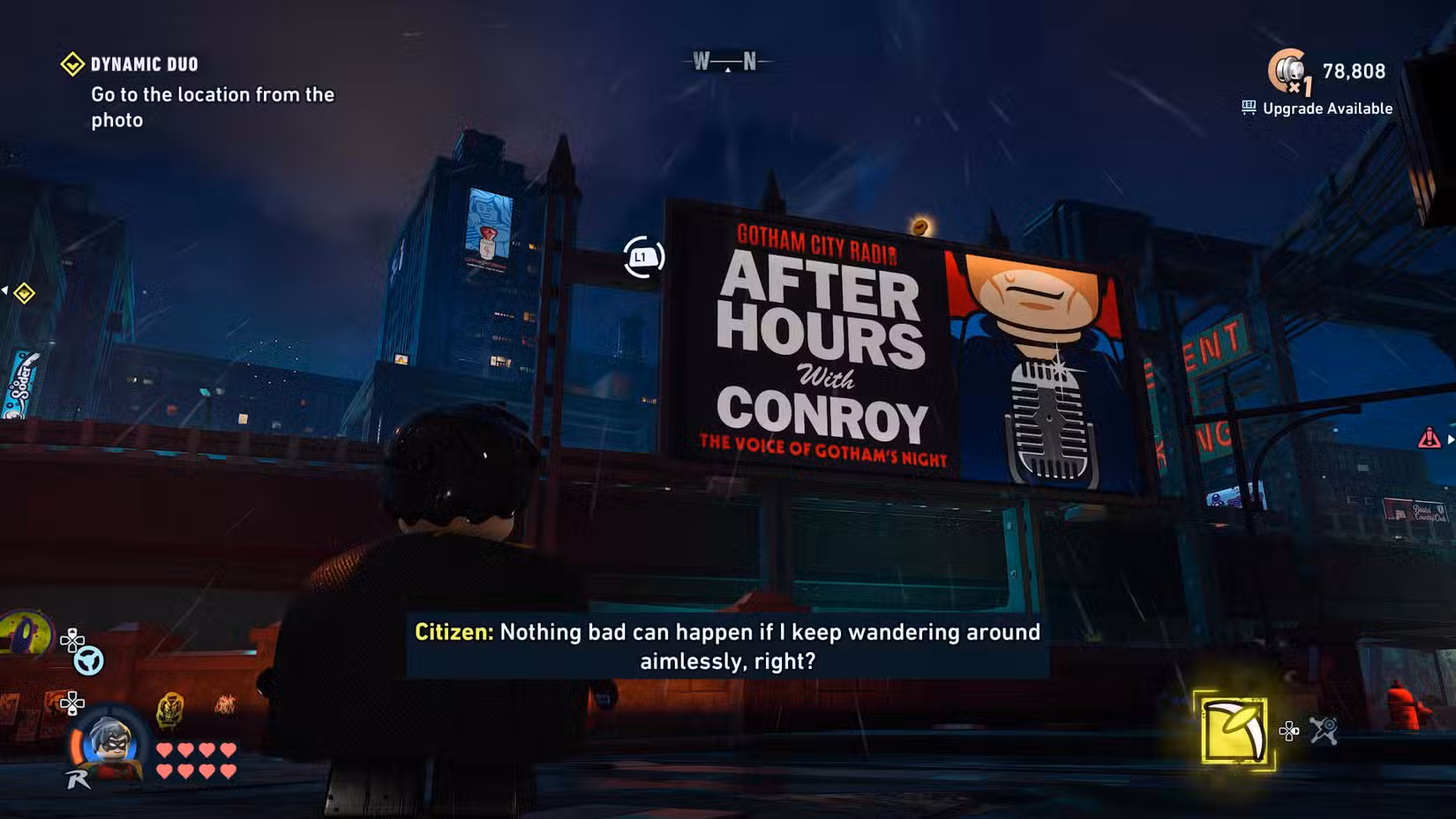 Captura de tela do Lego Batman: O Legado do Cavaleiro das Trevas mostrando um outdoor com gatos como uma homenagem a Kevin Conroy