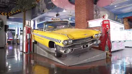 Um verdadeiro Cadillac dos anos 1960 pintado em amarelo táxi, como em Crazy Taxi, é retratado em um display da Sega