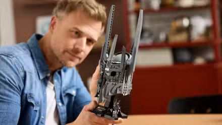 Foto de um homem construindo o conjunto de capacete Lego Senhor dos Anéis Sauron