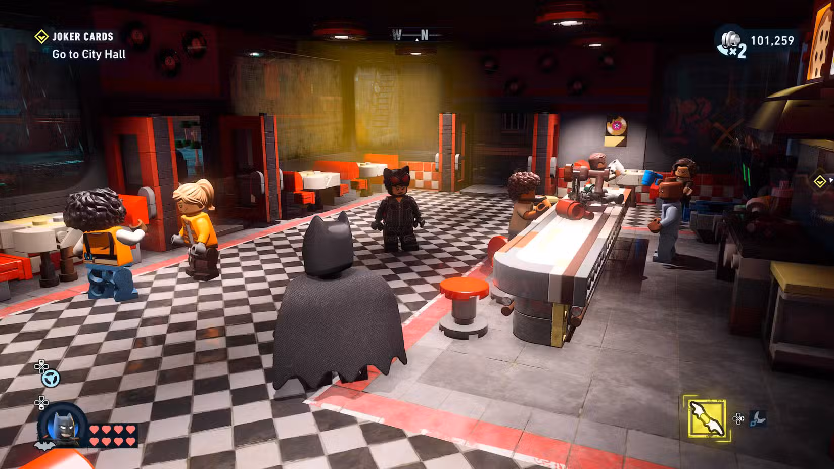 Captura de tela do Lego Batman Legacy of the Dark Knight mostrando Batman e clientes em uma lanchonete