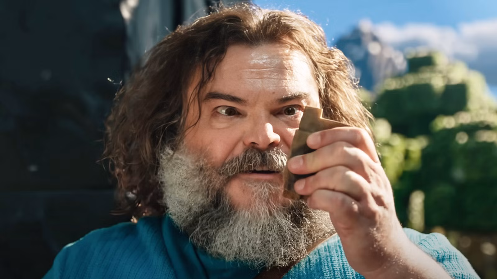 Jack Black como Steve em A Minecraft Movie, olhando atentamente para algum minério.