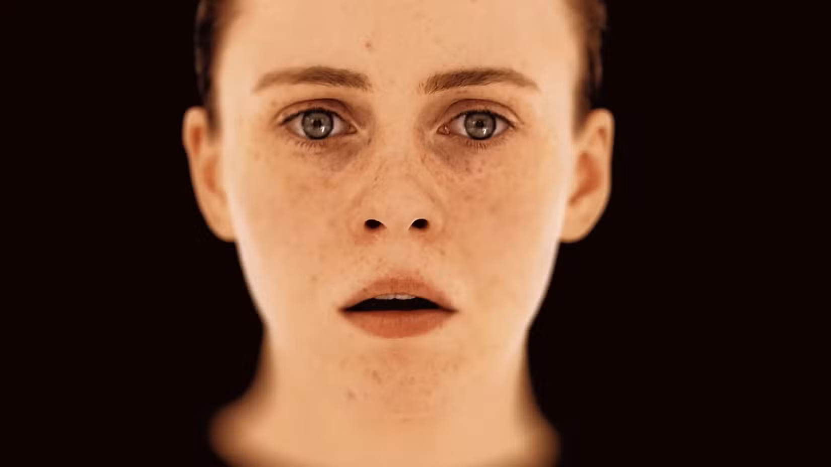Um close-up bem iluminado da atriz Sophia Lillis parecendo assustada, com o reflexo de uma sala e uma porta nos olhos, do trailer de OD