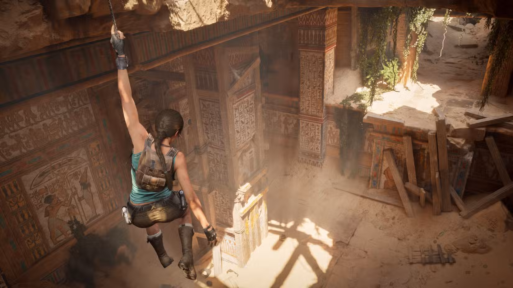 Lara Croft está pendurada em uma viga em Tomb Raider: Legacy of Atlantis.