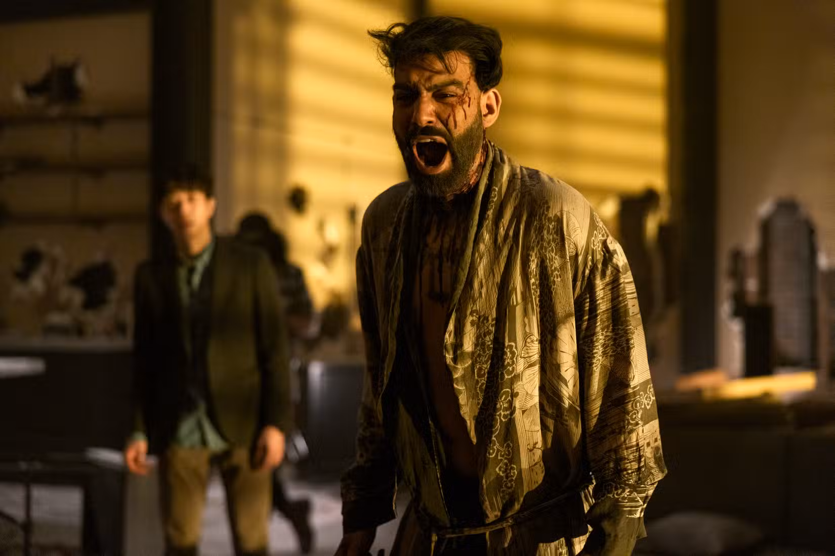 (LR) Daniel Jun como Julius, Rahul Kohli como Napoleão Usher gritando em um manto coberto de sangue em A Queda da Casa de Usher.