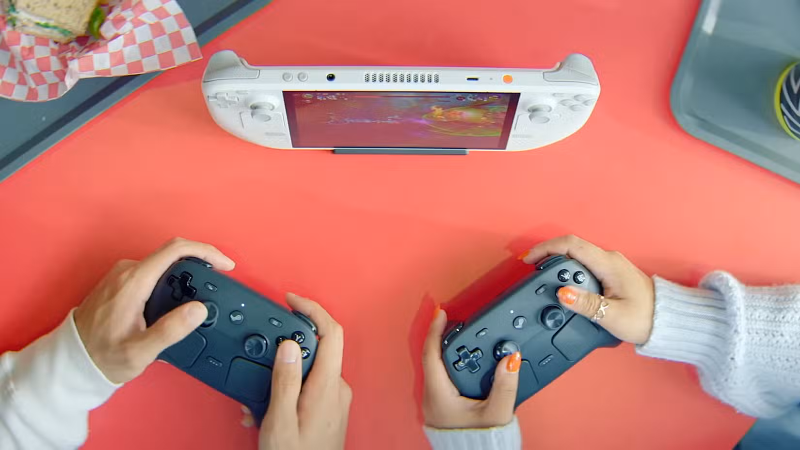 Uma foto de dois jogadores usando controladores Steam para jogar em um PC portátil