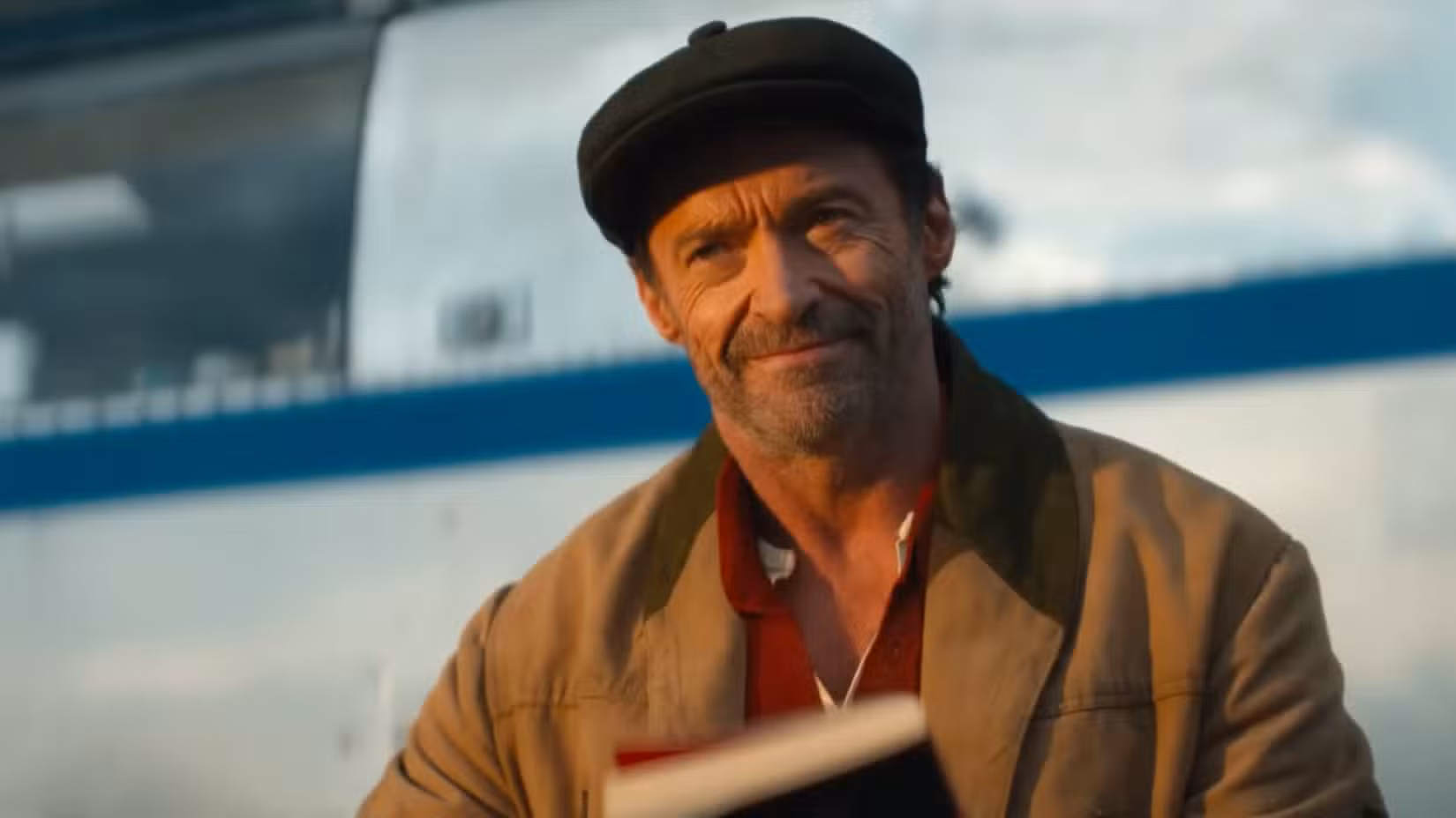 Captura de tela do Sheep Detectives mostrando Hugh Jackman parecendo satisfeito enquanto segura um livro