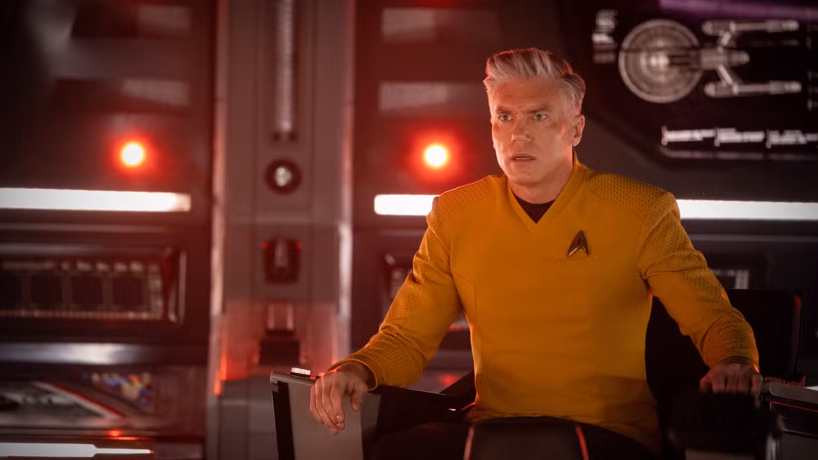 Pike sentado em sua cadeira de comando em uma foto da 4ª temporada de Star Trek: Strange New Worlds