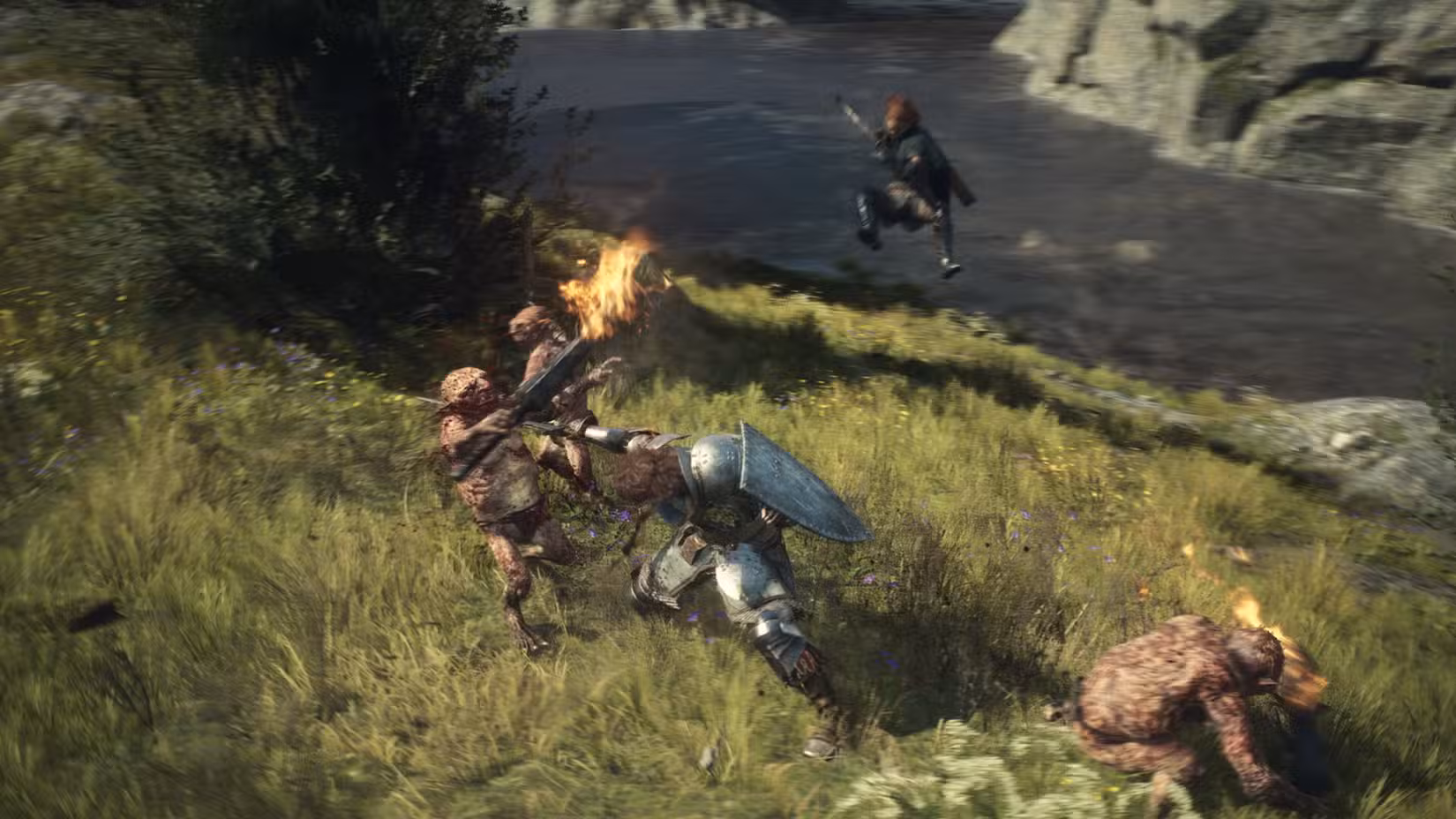 Um guerreiro esfaqueia um goblin na garganta perto de um rio em Dragon's Dogma 2. No fundo, um arqueiro mira e salta